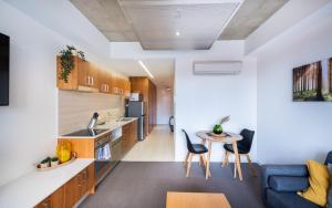 cocina y sala de estar con sofá y mesa en Mode Apartments Braddon ACT, en Canberra
