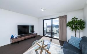 a living room with a couch and a tv at Century 23 Griffith in Canberra