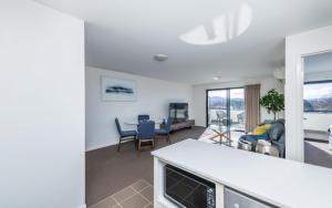 a kitchen and living room with a table and chairs at Century 23 Griffith in Canberra