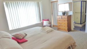 a bedroom with a large white bed and a dresser at Flinders Lodge 3, 3 - 22 Clarence St in Yamba +5 photos