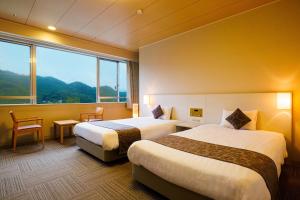 Yorii的住宿－KAMENOI HOTEL Nagatoro Yorii，酒店客房设有两张床和大窗户。