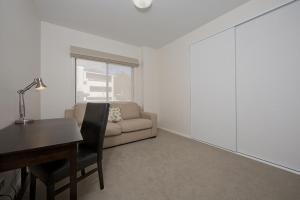 ein Wohnzimmer mit einem Schreibtisch und einem Sofa in der Unterkunft Domain 8 Deakin ACT in Canberra