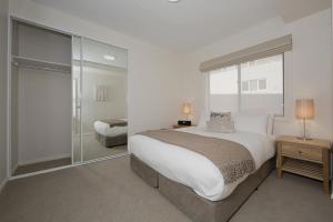 ein Schlafzimmer mit einem großen Bett und einer Glasschiebetür in der Unterkunft Domain 8 Deakin ACT in Canberra