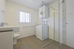 a white bathroom with a toilet and a sink at Domain 8 Deakin ACT in Canberra