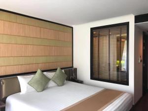 a bedroom with a white bed with a wooden headboard at The Beach by Glitter House in Kata Beach +22 photos