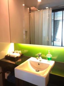 baño con lavabo y pared verde en The Beach by Glitter House, en Kata Beach