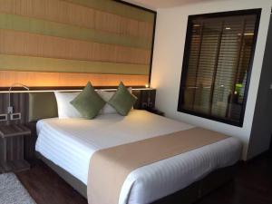 a bedroom with a large white bed with a window at The Beach by Glitter House in Kata Beach