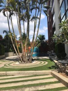 a resort yard with palm trees and a swimming pool at The Beach by Glitter House in Kata Beach