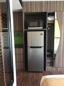 a small kitchen with a refrigerator and a microwave at The Beach by Glitter House in Kata Beach