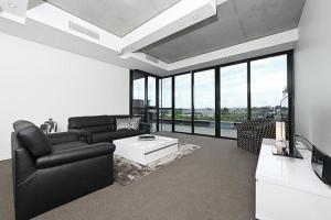 a living room with a couch and a table at The ApARTments 403 Canberra City ACT in Canberra