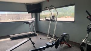 un gimnasio con dos máquinas de correr y una ventana en Condominio de lujo, en San Pedro Sula