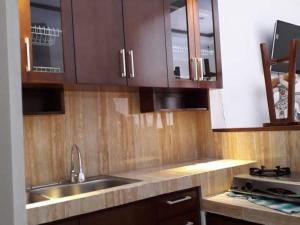uma cozinha com armários de madeira e um lavatório em Omahkoe Jongke em Sleman