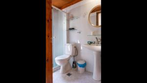 een badkamer met een toilet, een wastafel en een spiegel bij Beautiful house located on a hill, with a spectacular sea view in Koumeika