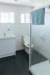 a bathroom with a toilet and a glass shower at Finlay Jack's Backpackers in Taupo