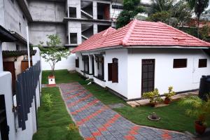 mały biały dom z czerwonym dachem w obiekcie Bobbys Corner w mieście Alappuzha
