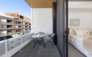 a bedroom with a bed and a table on a balcony at Azure 30 in Kingston 