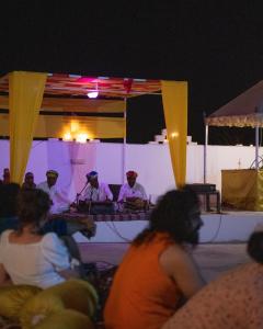 a group of people sitting in front of a stage at Real Desert Man Safari Camp in Jaisalmer