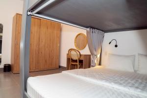 a bedroom with a bed and a desk with a chair at Mai Hotel in Vung Tau
