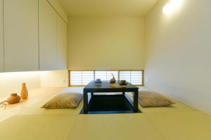 ein Zimmer mit einem Tisch und ein paar Vasen auf dem Boden in der Unterkunft Hostel Sapporo Hachijo Bettei in Okadamachō