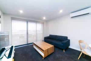 a living room with a blue couch and a coffee table at Accommodate Canberra - Indigo in Kingston 