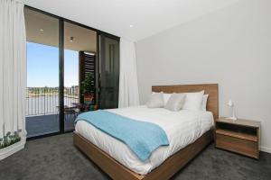 a bedroom with a large bed and a balcony at Pier 18 Kingston ACT in Kingston 