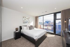a bedroom with a bed and a large window at Waygoose Street Residence Kingston ACT in Kingston 
