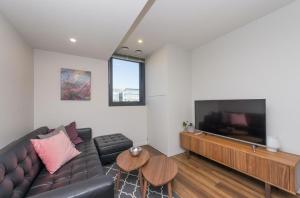 a living room with a couch and a flat screen tv at Waygoose Street Residence Kingston ACT in Kingston 