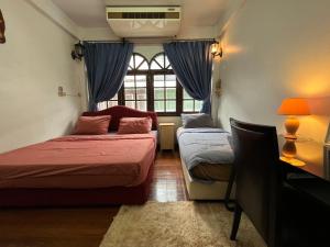 1 dormitorio con 2 camas y ventana en C U Again, en Bangkok