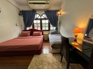 Habitación pequeña con 2 camas y ventana en C U Again, en Bangkok