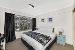 a bedroom with a large bed and a window at The Summit E2 Kingston ACT in Kingston 