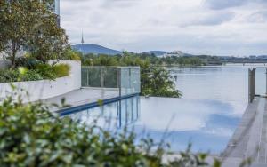 una piscina junto a un cuerpo de agua en Lakefront 116 Kingston ACT, en Kingston 