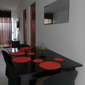 a black dining room table with red circles on it at Casa com 2 quartos e banheira de Hidromassagem in Trindade