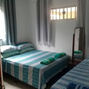 特林達德的住宿－Casa com 2 quartos e banheira de Hidromassagem，一间卧室配有一张带绿色和白色毯子的床