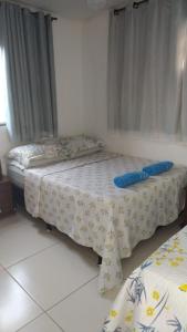 a bedroom with two beds with blue pillows on it at Casa com 2 quartos e banheira de Hidromassagem in Trindade