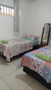 a room with two beds and a window at Casa com 2 quartos e banheira de Hidromassagem in Trindade