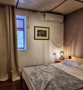 um quarto com uma cama e uma janela em Treehouse Hostel em Kuching