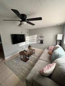 a living room with a couch and a ceiling fan at Bohemian 1 Bedroom- Minutes from Busch Gardens in Tampa