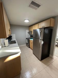 uma cozinha com um frigorífico de aço inoxidável e armários de madeira em Bohemian 1 Bedroom- Minutes from Busch Gardens em Tampa
