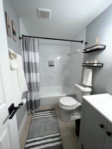La salle de bains blanche est pourvue d'une douche et de toilettes. dans l'établissement Bohemian 1 Bedroom- Minutes from Busch Gardens, à Tampa