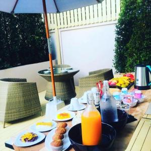una mesa con platos de comida y botellas de zumo de naranja en La La Moon Krabi Poshtel'n' Pool, en Krabi