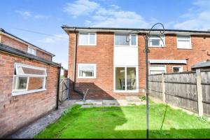 a brick house with a fence and a yard at 3 bed House Lovely & Modern in Whitefield