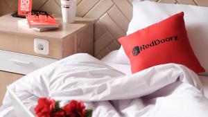 a bed with a red pillow with the word reactoit at Green Hotel near Lotte Center in Hanoi