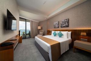 The Reef Island Resort Mactan, Cebu في ماكتان: غرفه فندقيه سرير كبير وتلفزيون