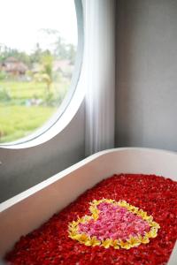 un gâteau en forme de cœur assis dans une boîte devant une fenêtre dans l'établissement Umah Tirta, à Ubud