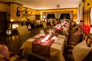 a row of tables in a restaurant with a fireplace at Wellness hotel V Nebi in Kořenov