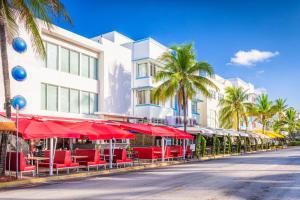 uma rua com cadeiras vermelhas e guarda-sóis em frente a um edifício em South of Fifth Ocean Drive Apt em Miami Beach