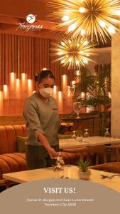 a woman standing in a restaurant wearing a mask at Ironwood Hotel in Tacloban