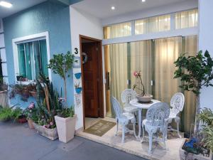 a patio with a table and chairs and plants at Casa Duplex Praia do Peró - Cinema em Casa in Cabo Frio