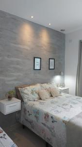 een slaapkamer met een bed en twee foto's aan de muur bij Casa Duplex Condomínio Ipanema no Peró in Cabo Frio