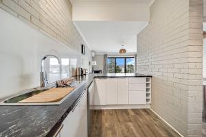 a white kitchen with a sink and a counter at Summit 11 Fabulous views and location in Jindabyne